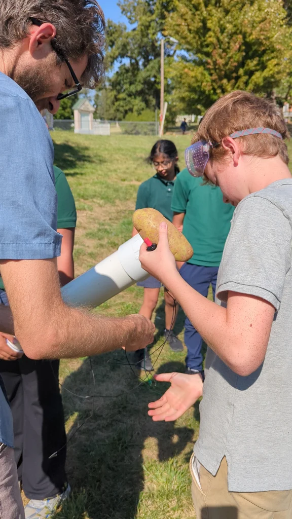 A middle school student launching a potato cannon