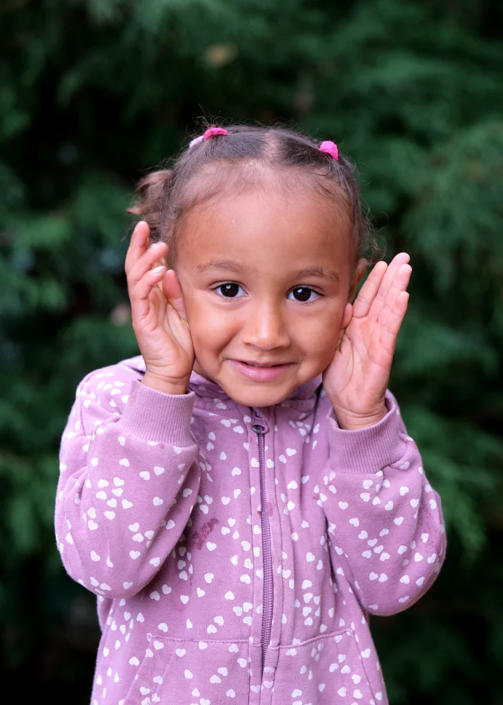 A preschool girl playing peekaboo