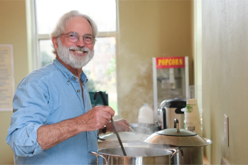 A faculty member cooking soup