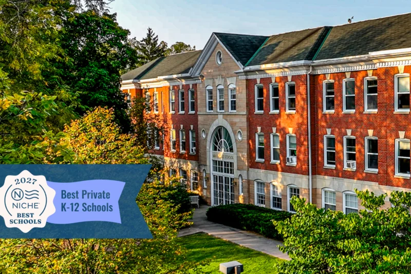 Maharishi school at sunrise with the soft sun illuminating the front of the building, featuring niche.com badge for 2027 best private K-12 school