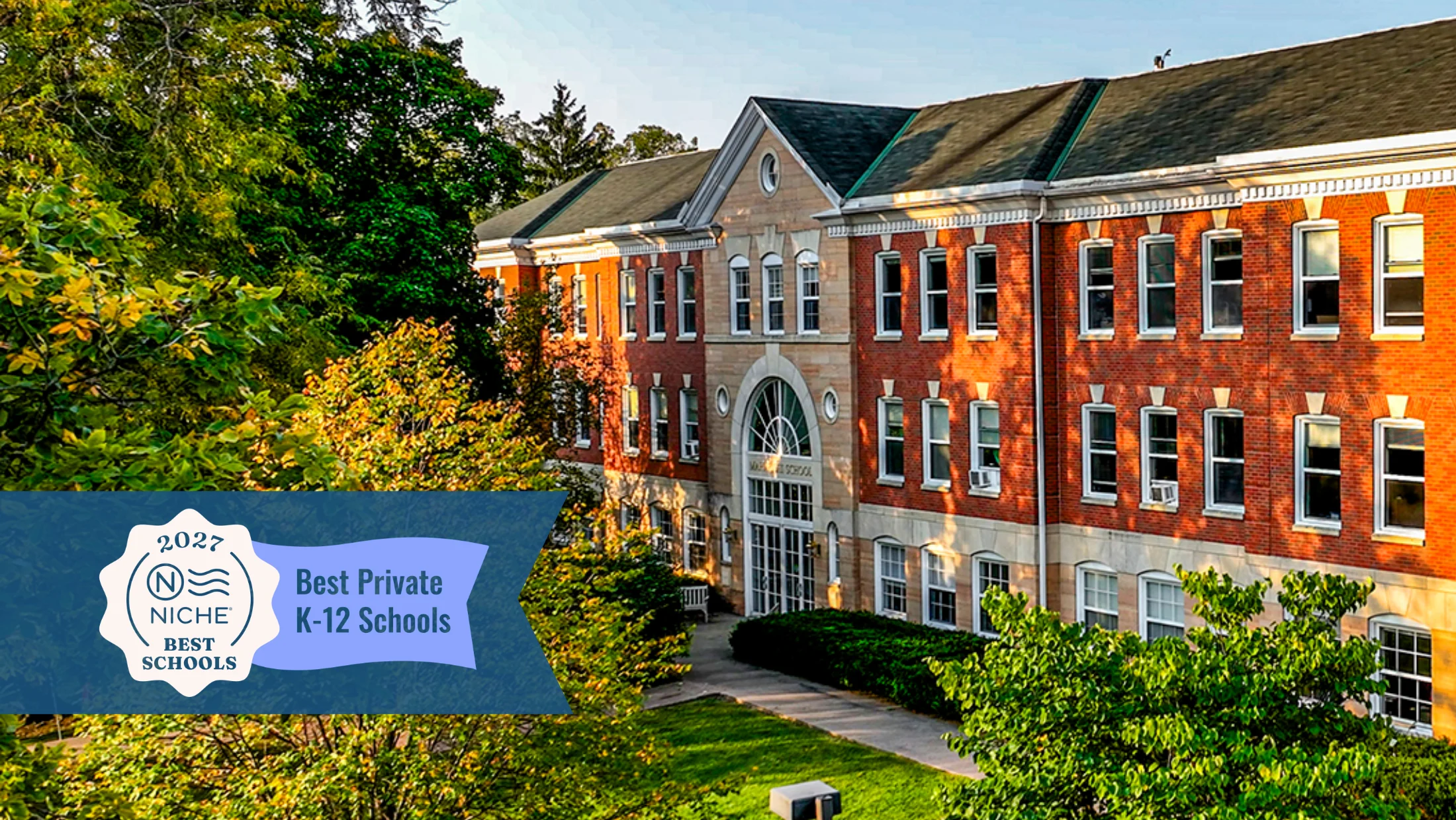 Maharishi school at sunrise with the soft sun illuminating the front of the building, featuring niche.com badge for 2027 best private K-12 school