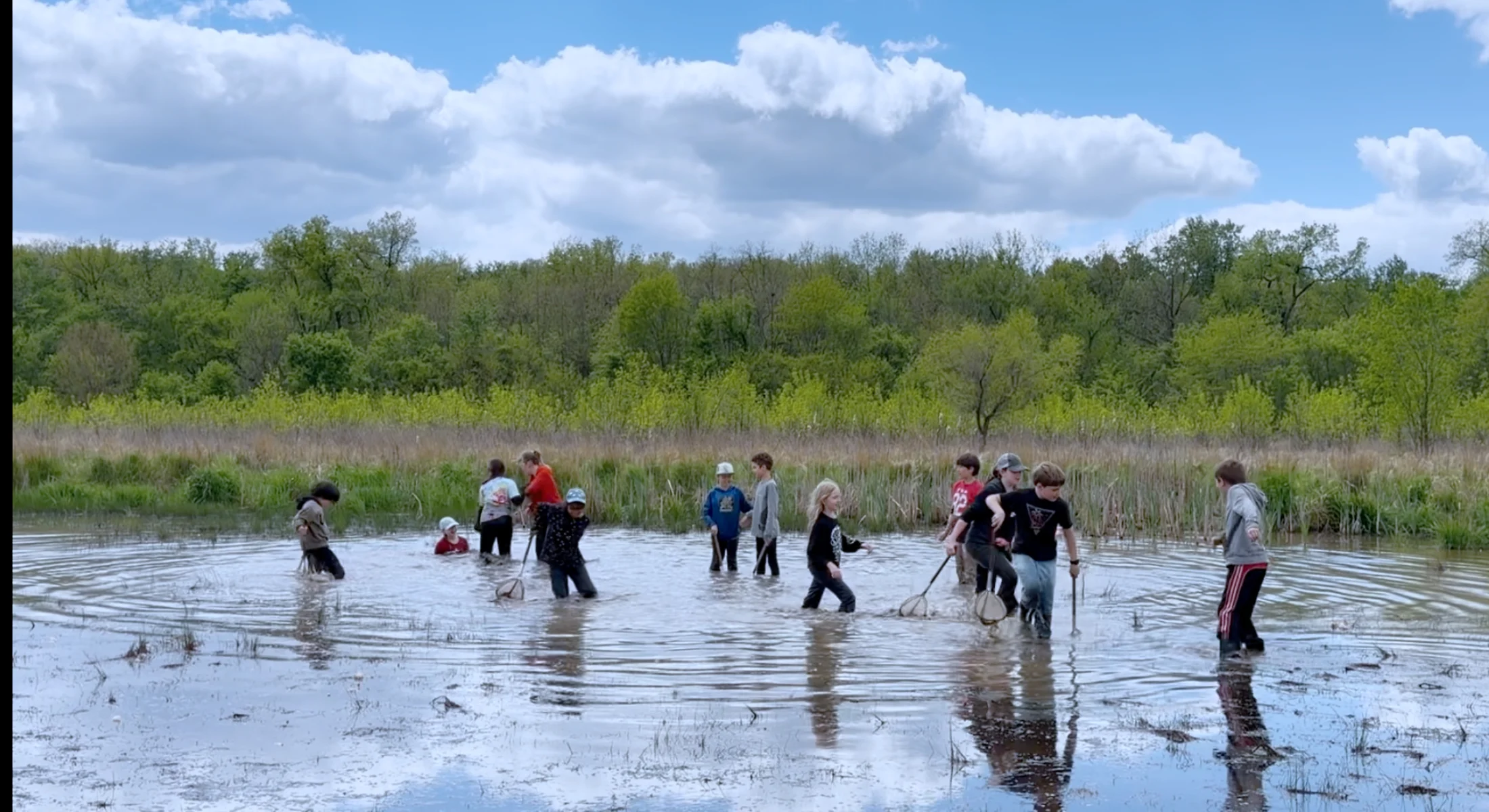 Middle school student tromping around in a swamp, having fun