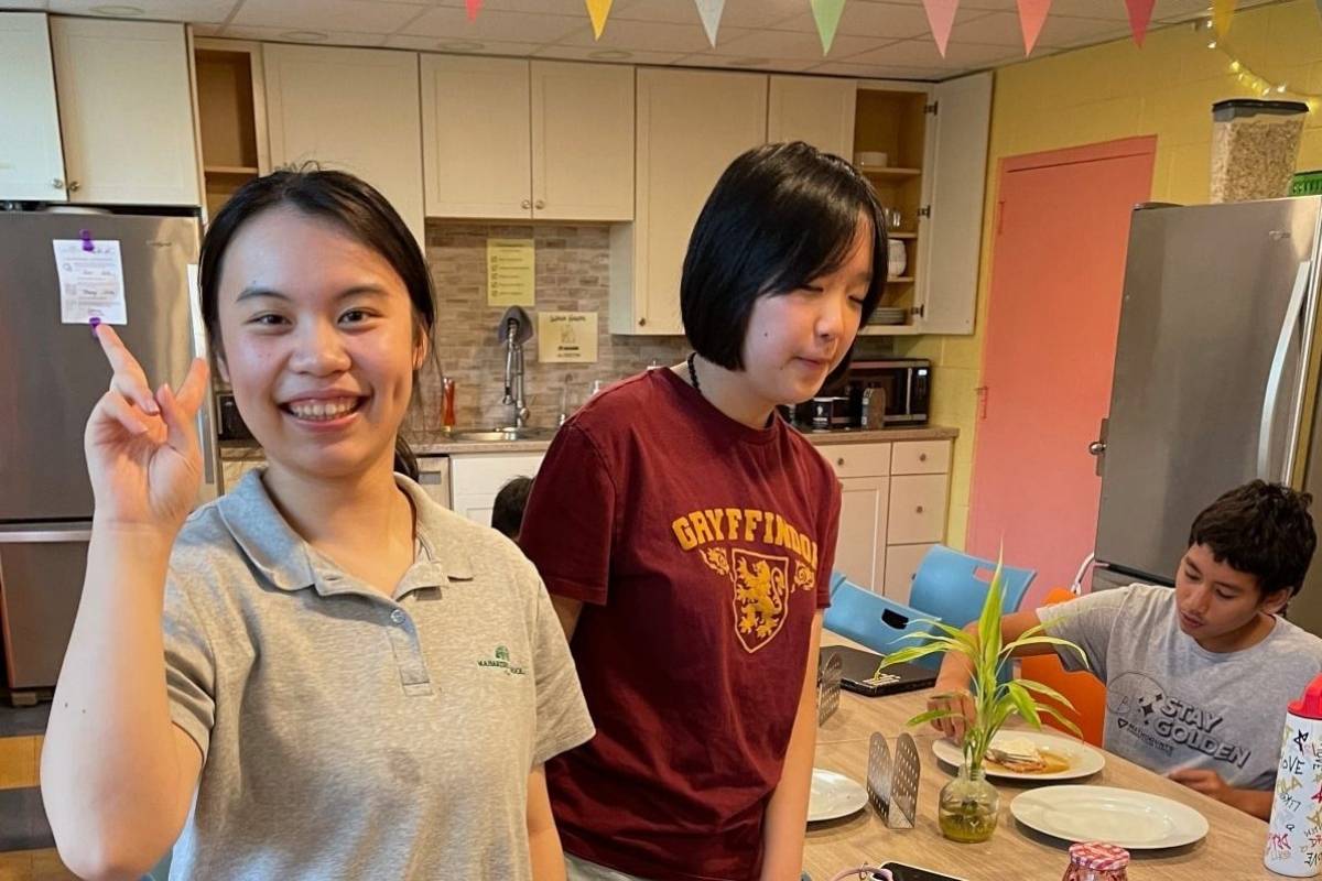 boarding students in student kitchen waving